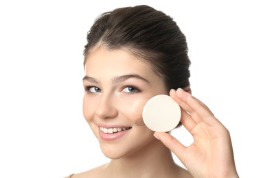 Beautiful girl with sponge on white background. Using concealer and foundation for face contouring