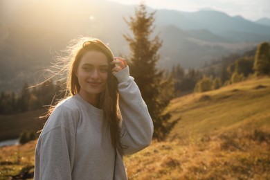 Beautiful young woman enjoying her time in mountains. Space for text