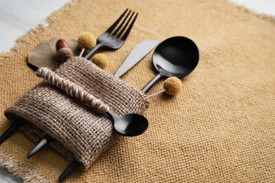 Photo of Autumn place setting with cutlery on white table, closeup. Space for text