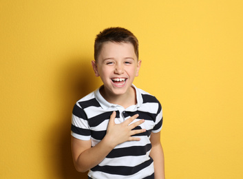Portrait of emotional preteen boy on yellow background