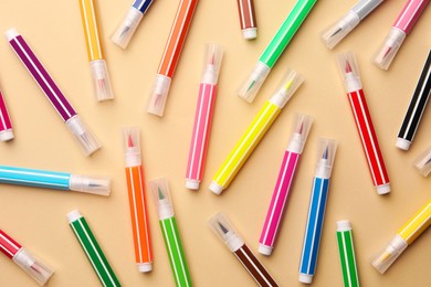 Photo of Many bright markers on beige background, flat lay
