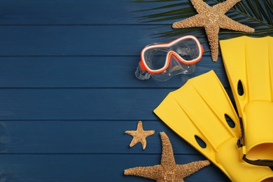 Flat lay composition with beach objects on blue wooden background, space for text