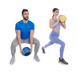 Athletic couple doing exercise with medicine balls on white background
