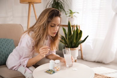 Woman holding glass of medicine for hangover at home