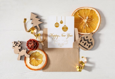 Flat lay composition with greeting card on white wooden table. Merry Christmas