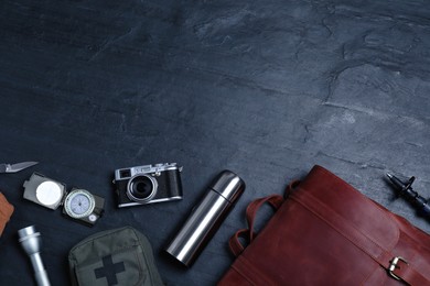 Flat lay composition with leather tourist backpack and camping equipment on black background, space for text