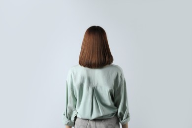 Girl wearing blouse on white background, back view