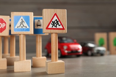 Many different miniature road signs on grey table, closeup with space for text. Driving school
