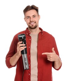 Smiling man pointing on sous vide cooker against white background