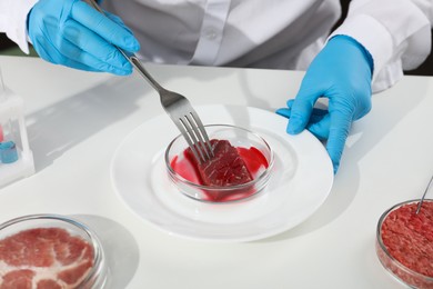 Scientist working with cultured meat in laboratory, closeup