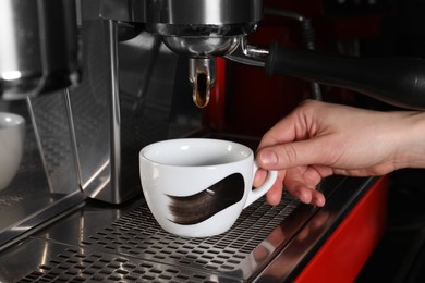 Barista making aromatic espresso using professional coffee machine in cafe, closeup
