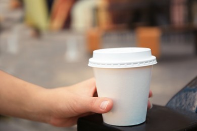 Photo of Woman with cardboard cup of coffee outdoors, closeup