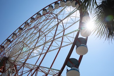 Beautiful Ferris wheel against blue sky on sunny day, low angle view