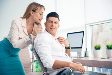 Young woman flirting with her colleague during work in office