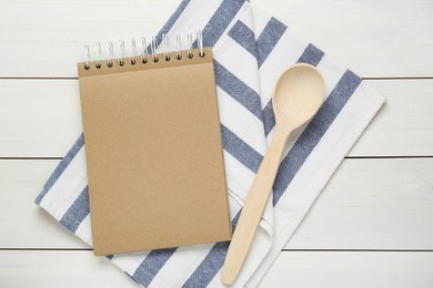 Photo of Blank recipe book and spoon on white wooden table, flat lay. Space for text