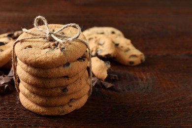 Photo of Delicious chocolate chip cookies on wooden table. Space for text