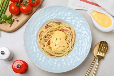 Delicious spaghetti with meat and cheese sauce served on light grey table, flat lay