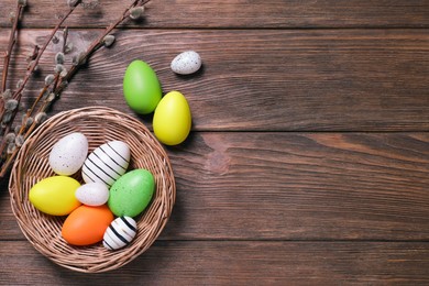 Photo of Flat lay composition with festively decorated Easter eggs and pussy willow branches. Space for text