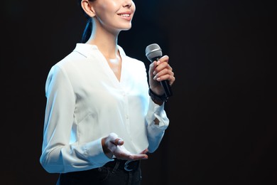 Photo of Motivational speaker with microphone performing on stage, closeup. Space for text