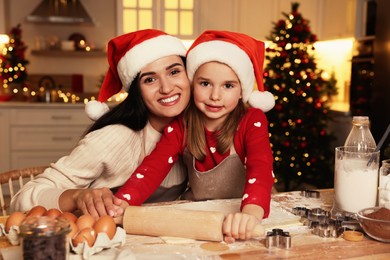 Happy mother and her daughter making delicious Christmas cookies at home
