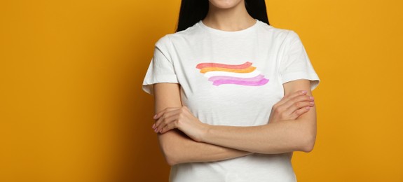 Young woman wearing white t-shirt with lesbian flag on orange background, banner design. LGBT concept