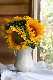 Beautiful sunflowers in vase near window indoors