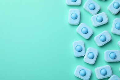 Photo of Water softener tablets on turquoise background, flat lay. Space for text