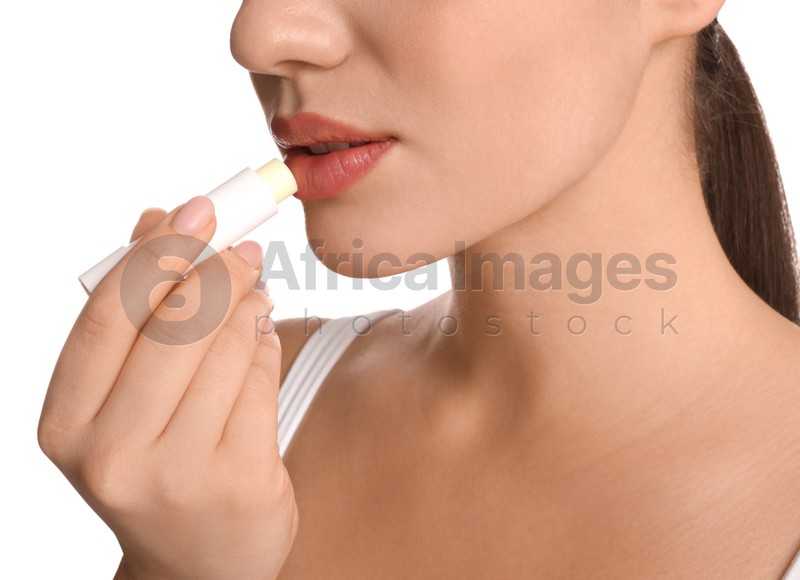 Young woman applying lip balm on white background, closeup