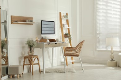 Comfortable workplace with modern computer and lamp in room. Interior design