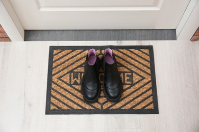 Stylish shoes on door mat in hall, above view
