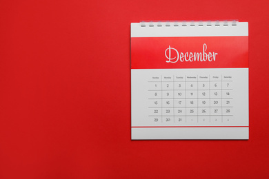 December calendar on red background, top view. Space for text