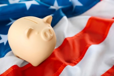 Photo of Piggy bank on American flag, closeup. Space for text