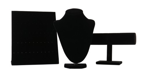 Different empty black velvet jewelry stands on white background