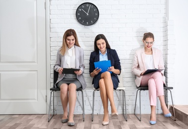Photo of Young women waiting for job interview, indoors