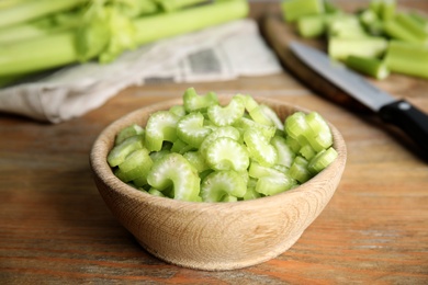 Photo of Cut celery in bowl on wooden table