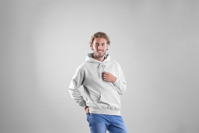 Photo of Portrait of man in hoodie sweater on light background. Space for design