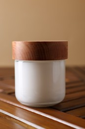 Jar of luxury cream on wooden table, closeup