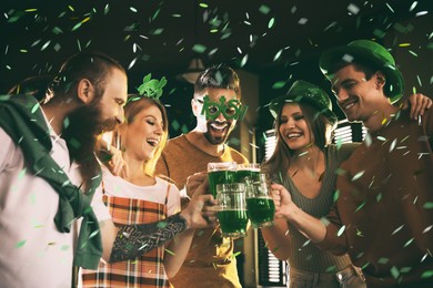 Group of friends toasting with green beer in pub.St. Patrick's Day celebration