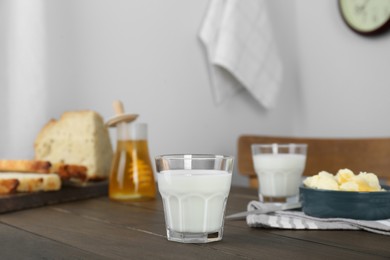 Photo of Delicious milk, honey, butter and bread served for breakfast on wooden table