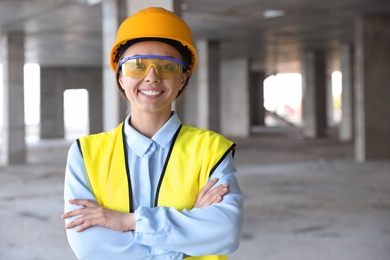 Professional engineer in safety equipment at construction site, space for text