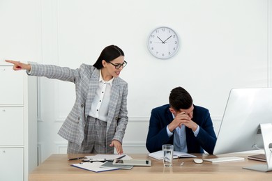 Photo of Boss screaming at employee in office. Toxic work environment