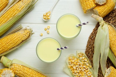 Photo of Flat lay composition with tasty fresh corn milk in glasses on white wooden table