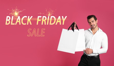 Black Friday Sale. Young handsome man with shopping bag on pink background, banner design