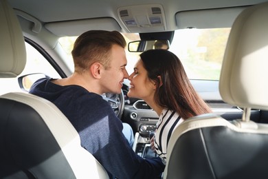 Happy young couple doing nose rub in car