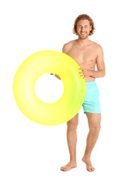 Attractive young man in swimwear with yellow inflatable ring on white background