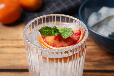 Delicious refreshing drink with sicilian orange and mint on wooden table, closeup