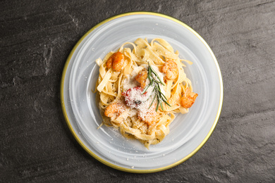 Photo of Delicious pasta with shrimps on black table, top view