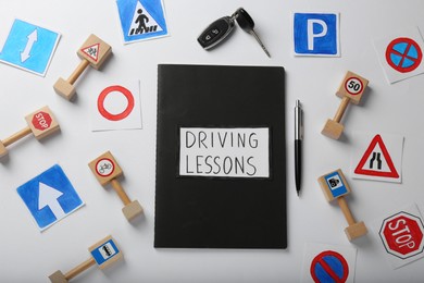 Composition with workbook for driving lessons on white background, top view. Passing license exam