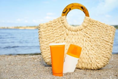 Photo of Composition with bottles of sun protection body cream on beach