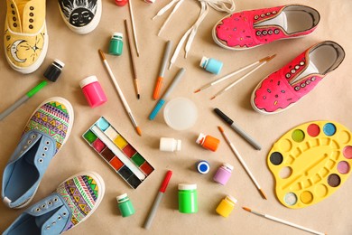 Photo of Amazing customized shoes and painting supplies on beige background, flat lay